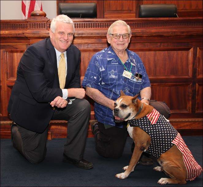 Chief Justice Mark Recktenwald (left) pauses for a photo with volunteers Ron Stebbins (center), and the First Circuit’s Veterans Treatment Court dog, Athena. 