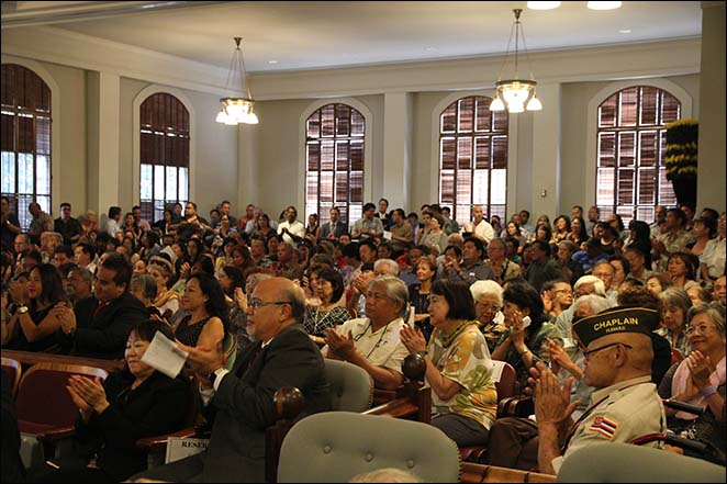 A crowd of well-wishers applause for the newly sworn in Judge William M. Domingo.