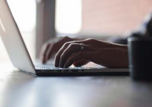 photo of unknown person typing on laptop keyboard