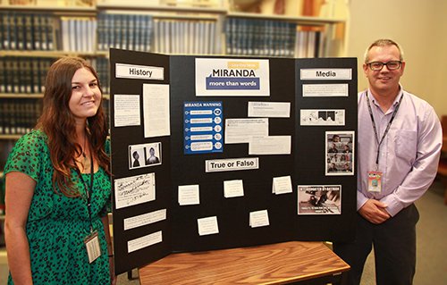 Two law library staff stand next to Law Day 2016 Miranda More Than Words display