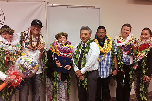 Hilo Drug Court Judge Greg Nakamura stands in the center of a group of six Big Island Drug Court graduates, all wearing leis, May19, 2016.