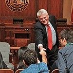 Chief Justice Mark Recktenwald in the Supreme Court courtroom shaking hands with a high school student from the University of Hawaii’s “Law and Justice Summer Program.”