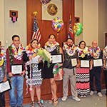 Chief Judge Randall Valenciano (left) and Judge Kathleen Watanabe (right) stand with eight program graduates at the Kauai Drug Court May 13, 2016 Graduation Ceremony.