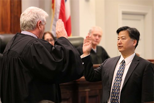 Chief Justice Recktenwald adinisters the oath of office to James Kawashima.
