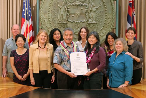 Hawaii Governor David Ige holds proclamation surrounded by 9 alternative dispute resolution practitioners.