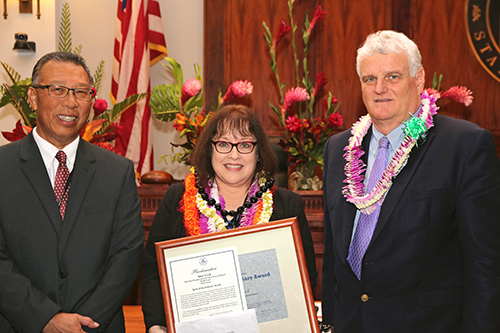 Mary Cook, Clerk IV, Juvenile Client Services Branch, Specialized Services Section, Kids First, First Circuit (Oahu) Family Court - Kapolei, with Intermediate Court of Appeals Associate Judge Derrick H.M. Chan and Hawaii Supreme Court Chief Justice Mark E. Recktenwald, in the Supreme Court courtroom, 09/30/2019.