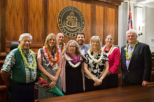 Hawaii Access to Justice Commission Chair Justice Simeon Acoba (ret.), attorney Christine Daleiden, attorney Gary Singh, attorney Denise George, attorney Wyatt Honse, attorney Barbara Ritchie, attorney Meredith Miller, and Hawaii Supreme Court Chief Justice Mark E. Recktenwald stand in front of the bench of the Hawaii Supreme Court courtroom at the annual Pro Bono Celebration, 10/24/2019.