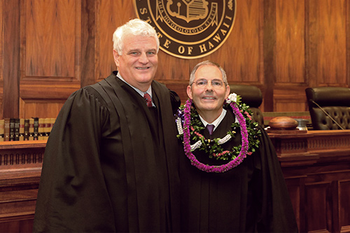 Chief Justice Mark E. Recktenwald and Associate Judge Clyde J. Wadsworth stand in front of the Hawaii Supreme Court courtroom bench after Wadsworth’s swearing in ceremony, 11/12/19.