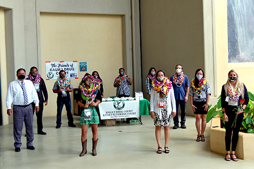 Fifth Circuit Deputy Chief Judge Michael K. Soong stands with 10 graduates at the 35th Kauai Drug Court graduation ceremony on 05/29/2020 at the Kauai Courthouse. All stand six feet apart and are wearing masks.