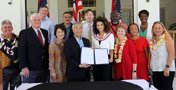 Photo of First row, left, David Lassner, Chief Justice Recktenwald, First Lady Dawn Amano Ige, Gov. David Ige, Samantha Neyland, Sen. Roz Baker, Sandy Ma, and Rep. Lynn DeCoite. Back row, left, Council Chair Tommy Waters, Rep. John Mizuno, Ty Trumbo, Alphonso Braggs, and Letitia Brown.