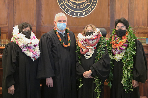 From left: Judge Clarissa Y. Malinao, Chief Justice Mark E. Recktenwald, Judge Shanlyn A.S. Park, and Judge Kevin T. Morikone stand together in front of the Hawaii Supreme Court bench, 12/16/2021.