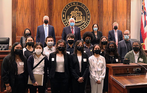 In the Hawaii Supreme Court Courtroom, Justices stand at the bench, as students and a teacher gather in front of the bench, 06/08/2022.