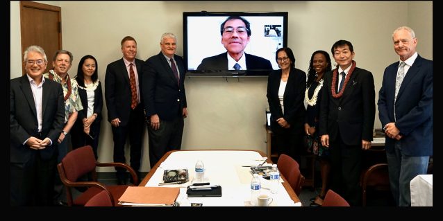 Associates of the University of Hawaii William S. Richardson School of Law, Hawaii State Bar Association International Law Section, and the Hawaii Supreme Court stand to the left and right of a large video screen transmitting a live-feed from Japan of Associate Justice Katsuya Uga of the Supreme Court of Japan, 05-03-2022.