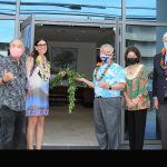 Alana Kobayashi Pakkala and Gov. David Ige untie a lei in front of the open doors of the new Hale Kalele multi-use building, with Kobayashi Group representatives on the left and First Lady Dawn Amano-Ige, Hawaii Supreme Court Chief Justice Mark Recktenwald, and Kahu Kordell Kekoa on the right, 05/05/2022.
