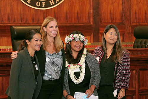 Attorney Katherine Lukela, Hawaii State Bar Association President Shannon Sheldon, Nanakuli High & Intermediate School student Shandette Namulauti, and Erin Kobayashi stand together in front of the Hawaii Supreme Court bench at the Pro Bono Celebration, 10/27/2022.
