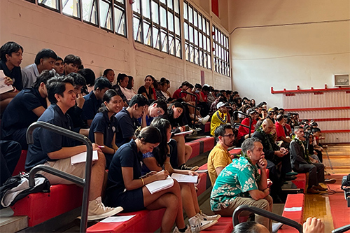 Students, teachers, and special guests sitting in the stands of the Lahainaluna High School gymnasium, 12-06-2022.