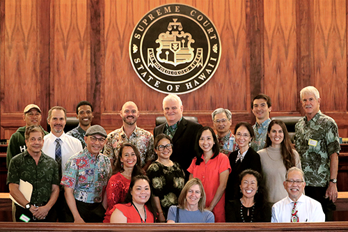Attorneys and Judiciary staff who provided support for the Honolulu District Court Access to Justice Room stand togther at the front of the Hawaii Supreme Court courtroom, 12/16/2022.