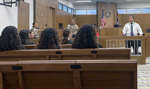 Image of Third Circuit Chief Judge Robert Kim speaking to students. Deputy Sheriffs Lynn Furuto and Dustin Ballesteros also spoke.