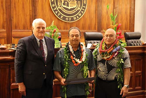 Hawaiʻi Supreme Court Chief Justice Mark Recktenwald, Maui Drug Court Certified Substance Abuse Counselor Armon Tavares, and Administrative Director of the Courts Rodney Maile in front of the Hawaiʻi Supreme Court courtroom bench, 09/29/2023.