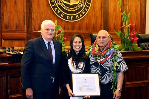 Hawaiʻi Supreme Court Chief Justice Mark Recktenwald, Third Circuit Human Resources Technician Donna Miura, and Administrative Director of the Courts Rodney Maile in front of the Hawaiʻi Supreme Court courtroom bench, 09/29/2023.