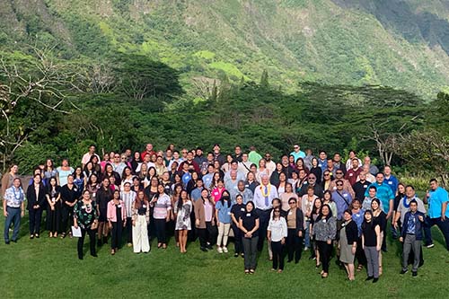 Group photo of the 2023 Statewide Adult Drug Court Conference attendees, outside overlooking the mountains at the Koʻolau Ballrooms & Conference Center, Kāne‘ohe, Oʻahu, Hawaiʻi, 10/17/2023.