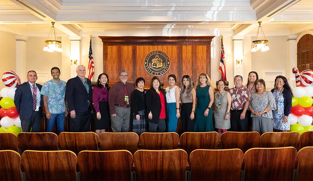Attorneys and Judiciary staff who provided support for the Kapolei Access to Justice Room stand together at the front of the Hawaii Supreme Court courtroom, 12/11/2023.