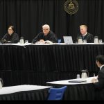 Hawaiʻi Supreme Court Associate Justice Lisa M. Ginoza, Associate Justice Sabrina S. McKenna, Chief Justice Mark E. Recktenwald, Associate Justice Todd W. Eddins, and Associate Justice Vladimir P. Devens sitting at the court’s bench in the Kailua High School gymnasium. On the left, Deputy Prosecuting Attorney Brian R. Vincent faces them from the podium. Courts in the Community, April 26, 2024.