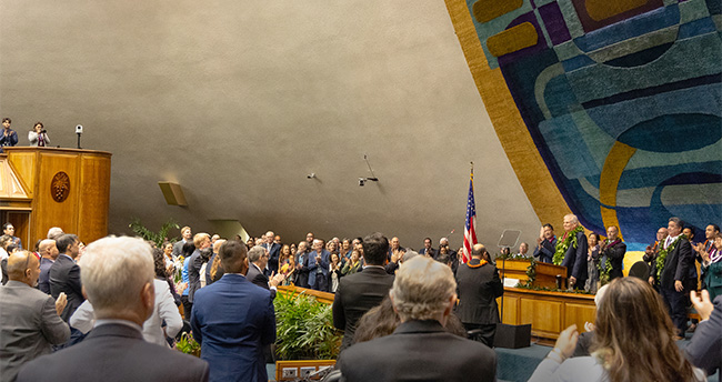 Attendees give a standing ovation for Hawaiʻi Supreme Court Chief Justice Mark E. Recktenwald, who stands at the Senate Chamber rostrum in the State Capitol, January 23, 2025.