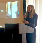 Judge Erika Ireland speaking from the podium at the 2025 Fair Housing for Our Future Laws & Litigation Conference in San Diego, California, with Shellie Park-Hoapili's name on Zoom projected on the screen positioned to the left of Judge Ireland, 02-13-2025.