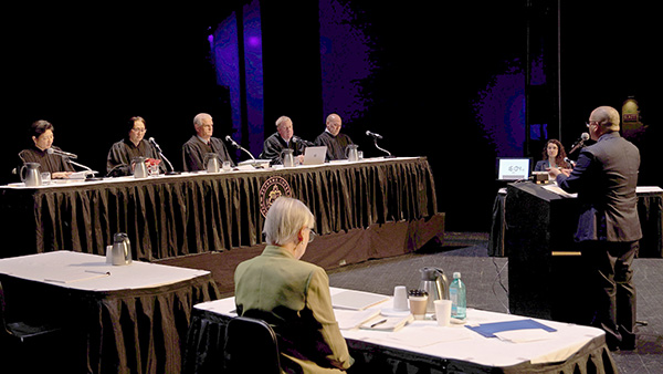 Hawaiʻi Supreme Court Associate Justice Lisa M. Ginoza, Associate Justice Sabrina S. McKenna, Chief Justice Mark E. Recktenwald, Associate Justice Todd W. Eddins, and Associate Justice Vladimir P. Devens at the bench, Hawaiʻi County Deputy Prosecuting Attorney Frederick M. Macapinlac at the podium, and attorney Georgette Anne Yaindl at the Petitioner's table. Courts in the Community at the University of Hawai‘i at Hilo Performing Arts Center, 04-17-2025.