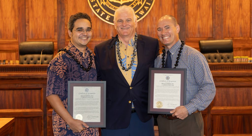 Chief Justice Mark Recktenwald and PACE Commission volunteers Troy Andrade and Steven Uejio are all smile as they pose for a photograph in the Supreme Court courtroom after Chief Justice Recktenwald presented them with Certificates of Appreciation.