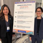 Third Circuit District Family Court Judge Darien Nagata and Legal Aid Society of Hawaii Senior Attorney Jessica Jaycee Uchida stand on either side of a sign titled "Domestic Relations" that provides information on presentations, including theirs, at NCJGCJ in Chicago, 07/21/2025.
