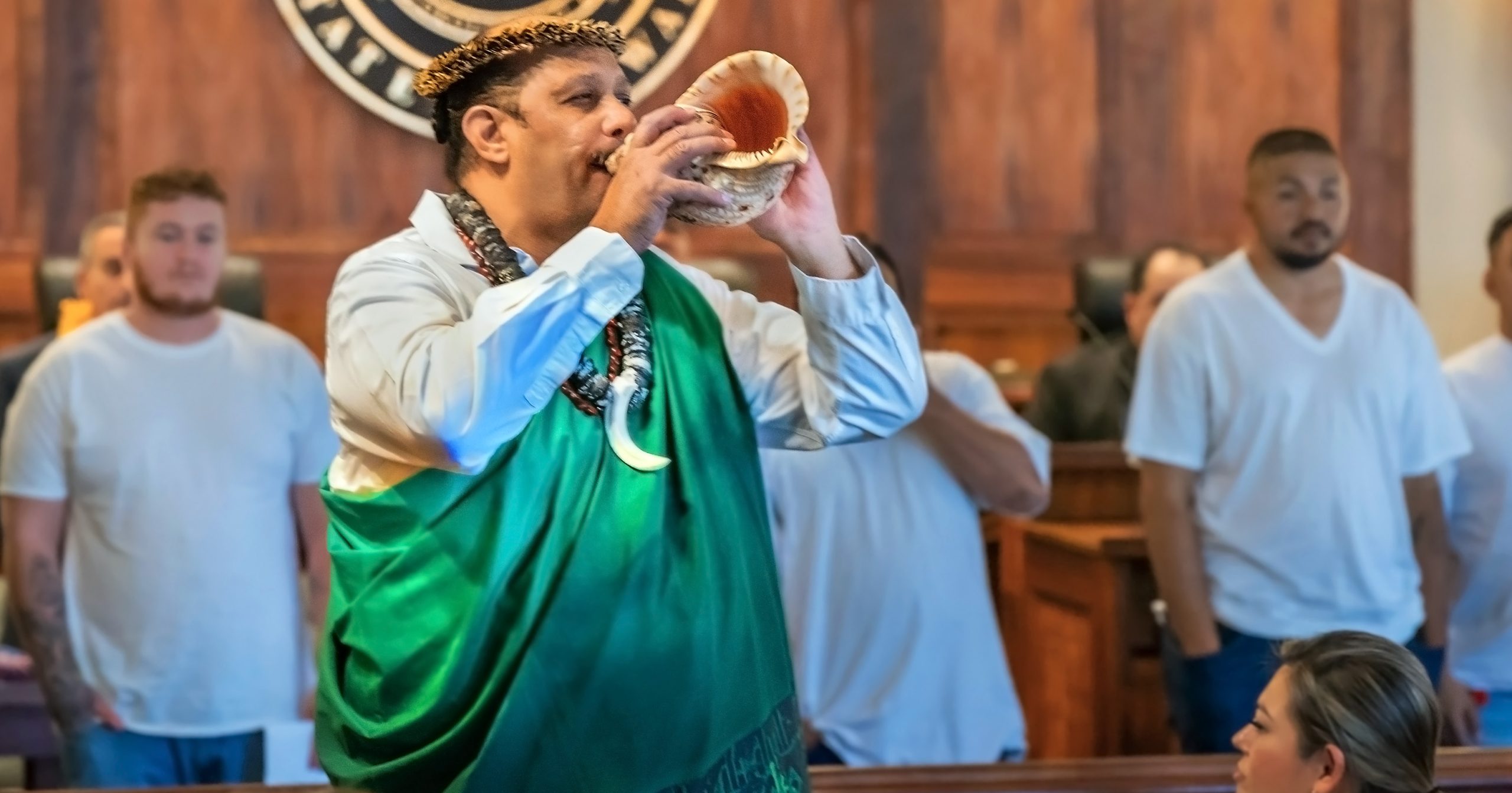 Veterans Treatment Court alumnus Joseph Quintero blows a conch shell to signal the start of the commencement ceremonies at the 2025 Hawaiʻi Drug Court, Veterans Treatment Court, and Mental Health Court Graduation.