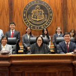Students from Hawai‘i Baptist Academy pose with Acting Chief Justice Sabrina S. McKenna (middle) in the Hawai‘i Supreme Court courtroom after winning the 2026 Hawai‘i High School Mock Trial Competition.