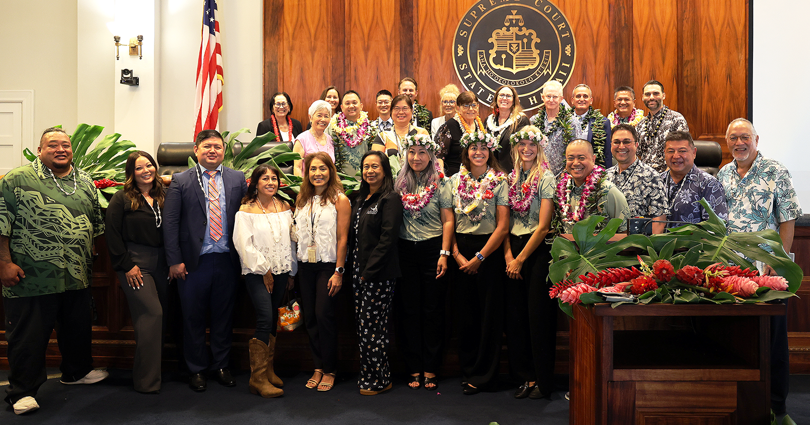 Current and former JDC judges, probation officers and team members pose in the Hawaiʻi Supreme Court courtroom at Aliʻiōlani Hale following the 25th anniversary celebration of the Juvenile Drug Court.